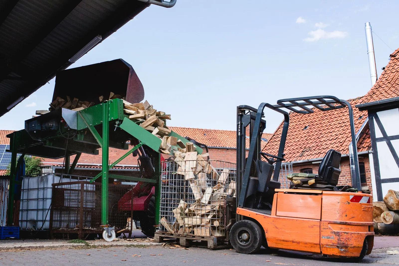 Holzscheite gelangen über die grüne Sieb- und Reinigungsanlage in eine Gitterbox