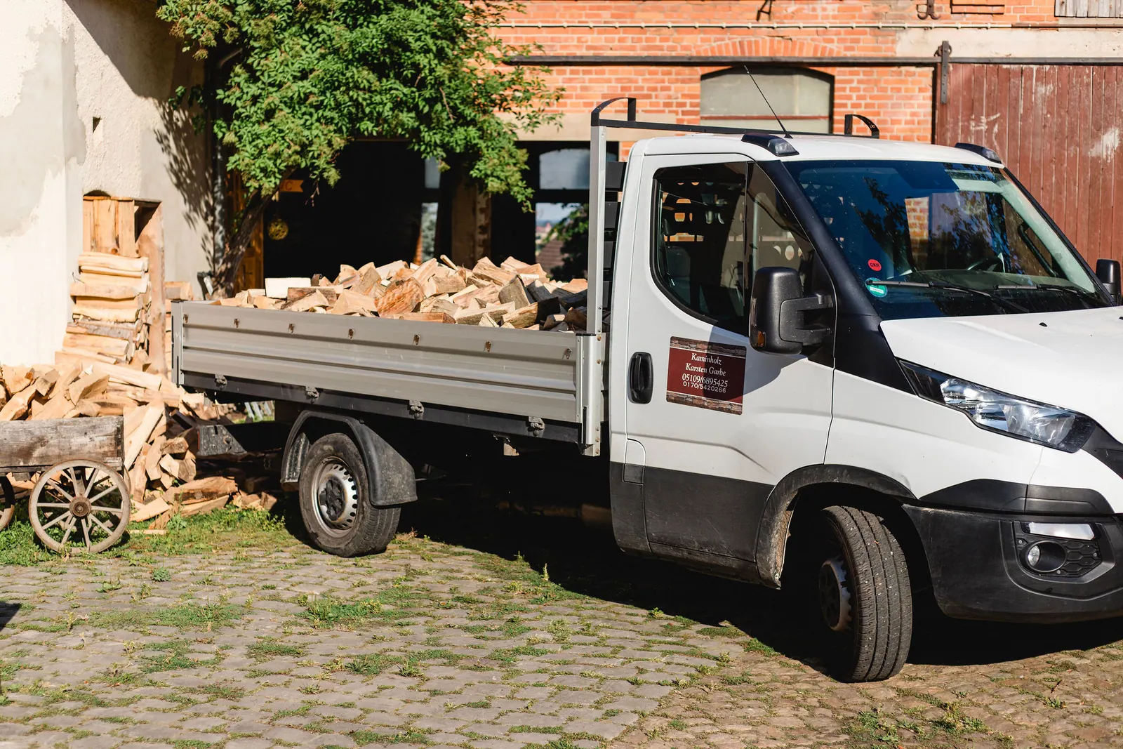 Mit Kaminholz beladener Transporter auf dem Betriebshof